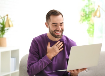 Man using laptop for video chat in living room