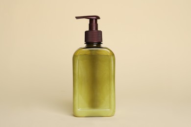 Bottle of face cleansing product on beige background. Space for text