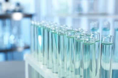 Photo of Test tubes with liquid on blurred background, closeup. Laboratory analysis