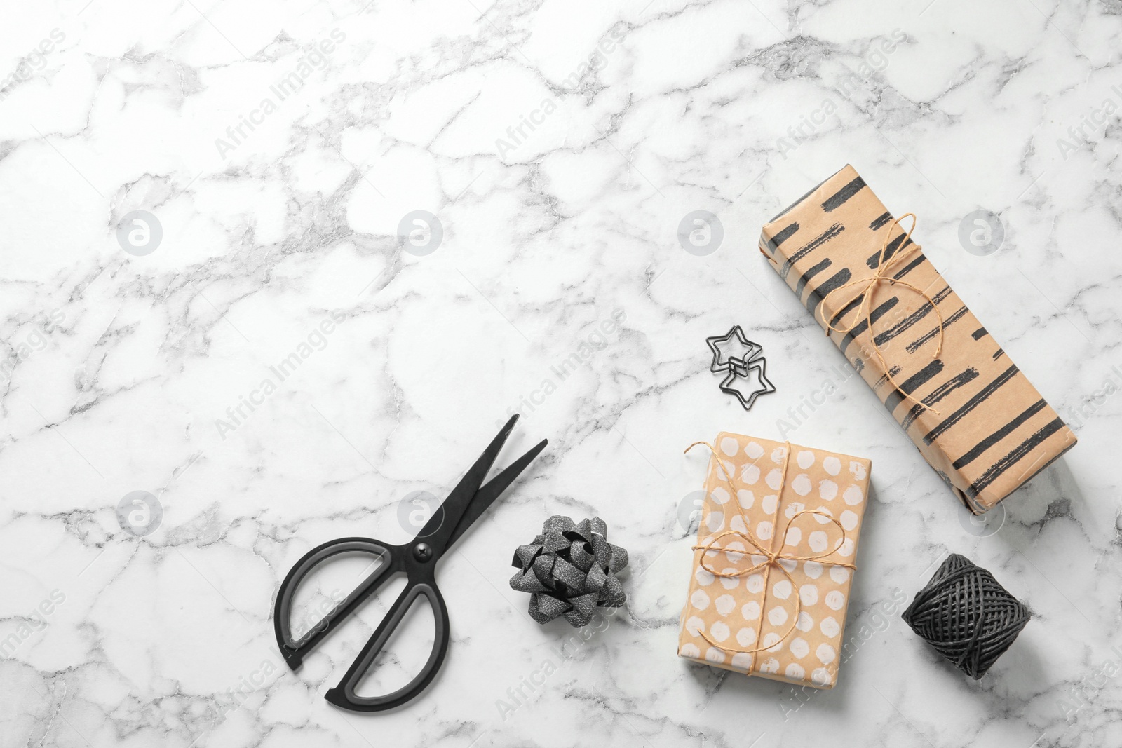 Photo of Flat lay composition with scissors and gift boxes on white marble table, space for text