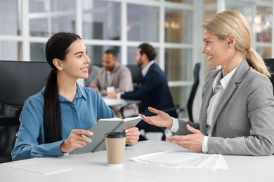 Lawyers with notebook working together at table in office, selective focus