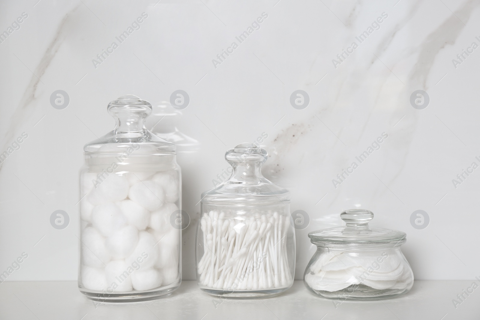 Photo of Cotton balls, swabs and pads on white table indoors