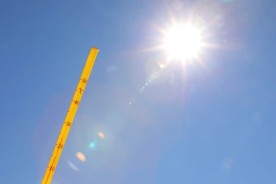 Weather thermometer against blue sky, space for text