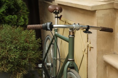 Photo of Green bicycle parked near building, closeup view