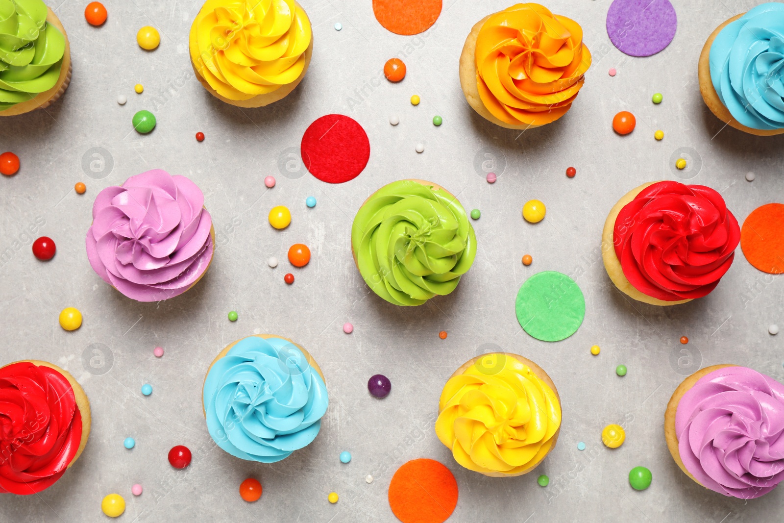 Photo of Colorful birthday cupcakes on light grey table, flat lay