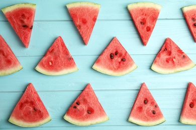 Photo of Slices of ripe watermelon on light blue wooden table, flat lay