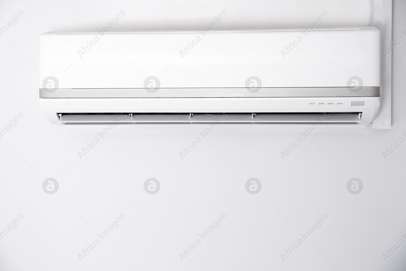 Photo of Modern air conditioner on white wall indoors