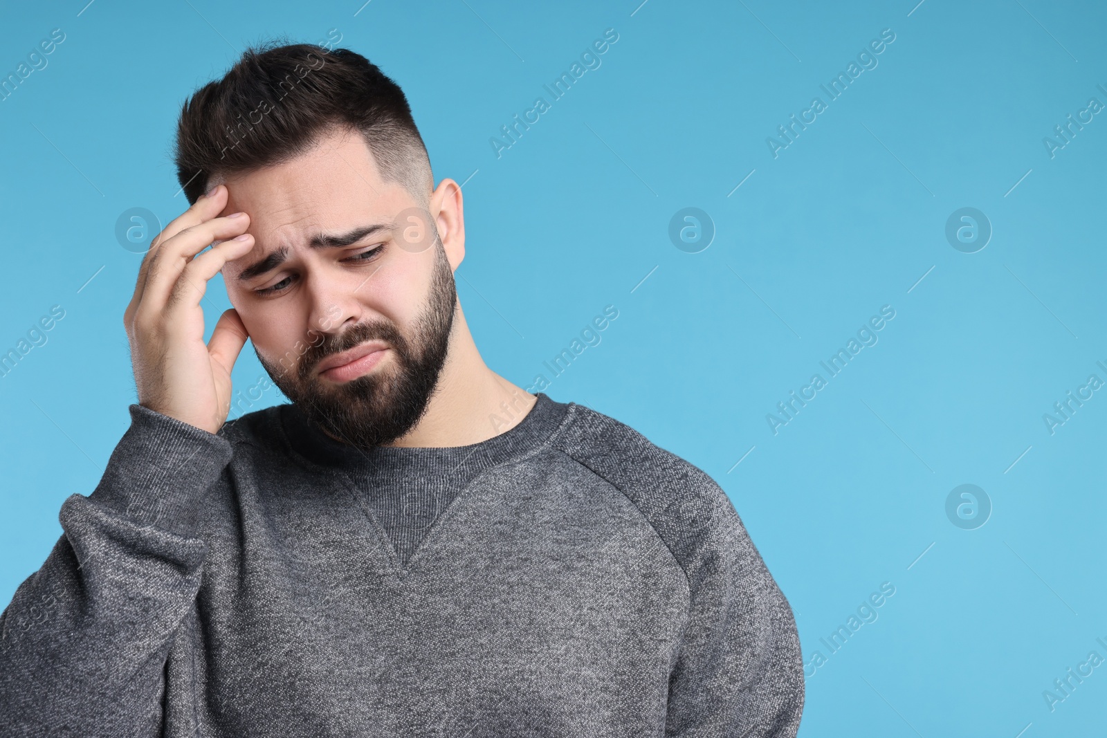 Photo of Portrait of sad man on light blue background, space for text