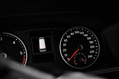 Modern speedometer, tachometer and open door warning sign on car dashboard