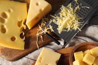 Photo of Grated, cut cheese and grater on table, flat lay