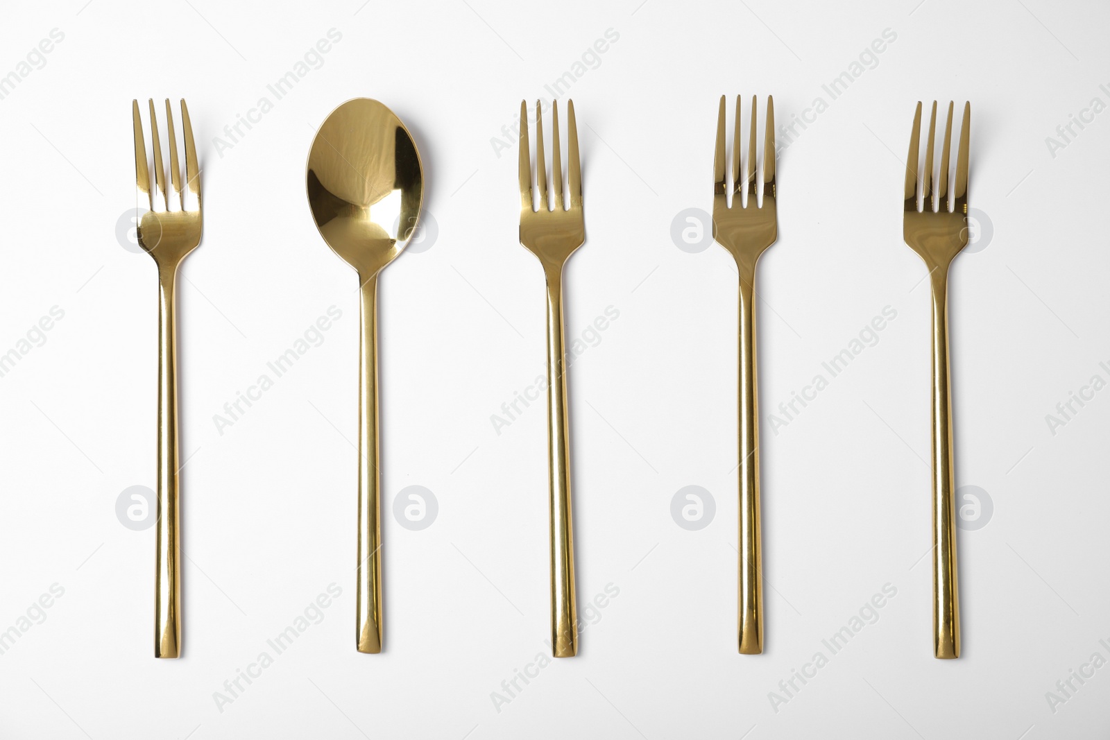 Photo of Set of new gold cutlery on white background, top view