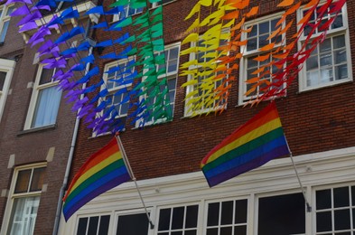 Photo of Bright rainbow LGBT pride flags on building facade