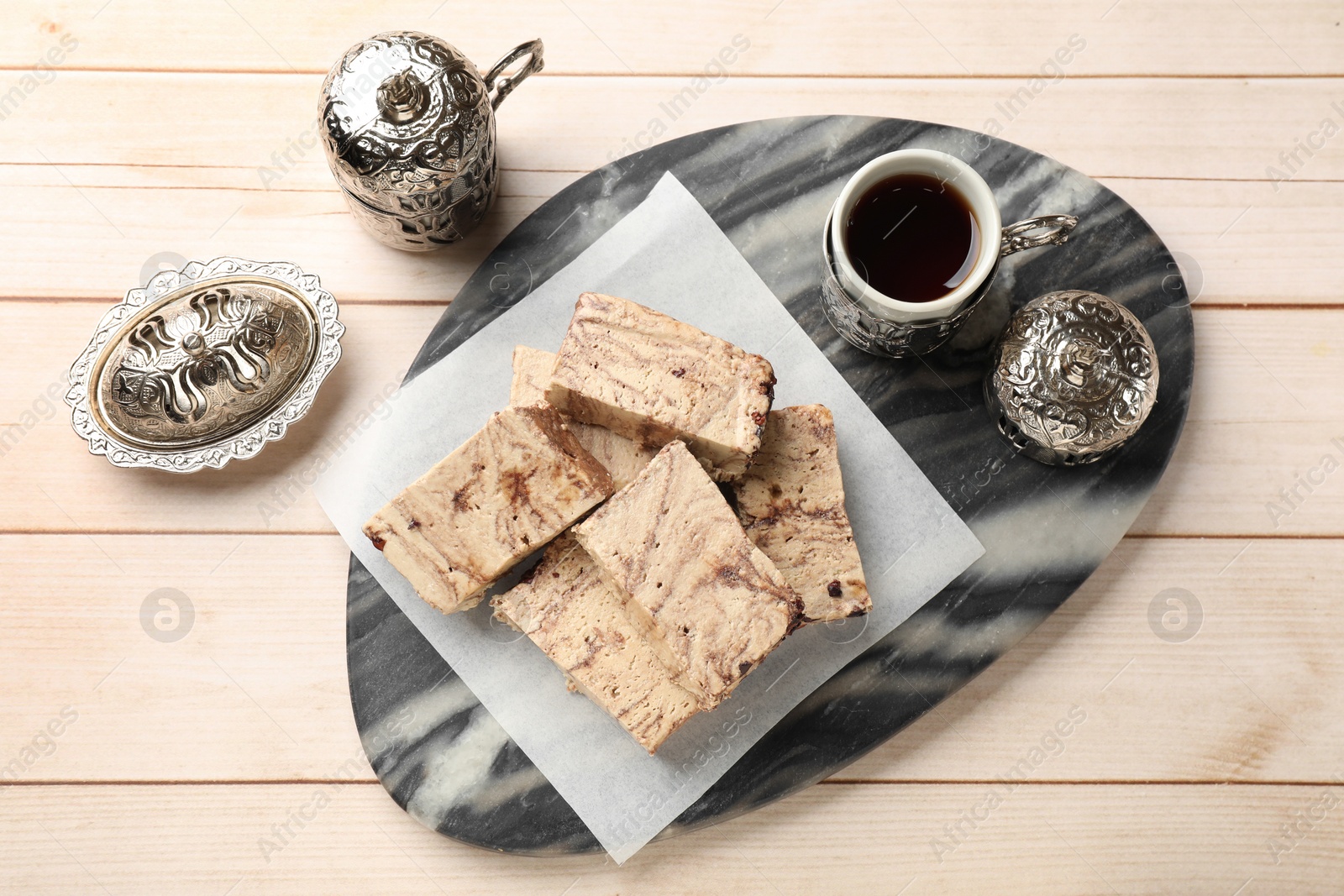 Photo of Tasty chocolate halva served on wooden table, flat lay