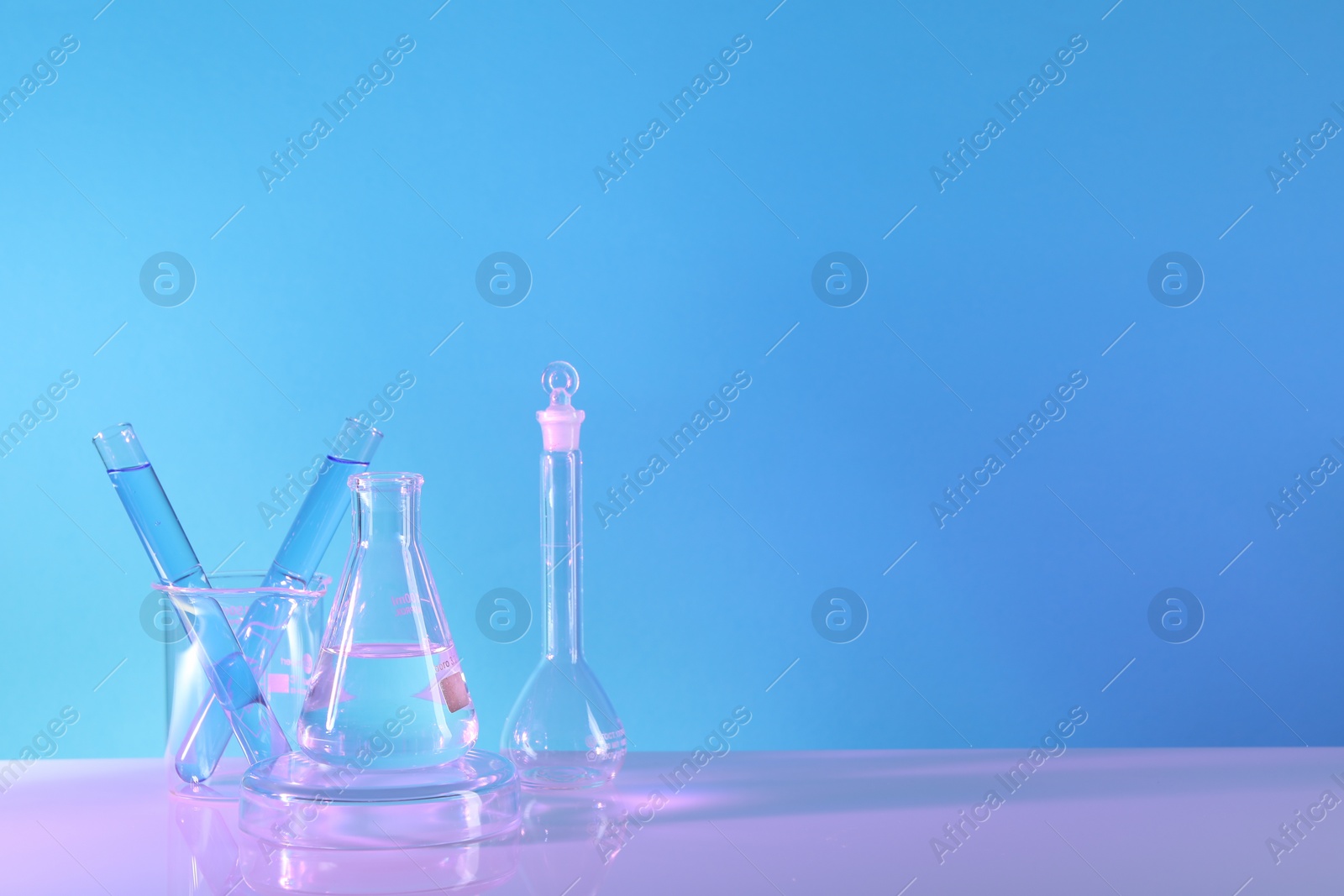 Photo of Laboratory analysis. Different glassware on table against light blue background