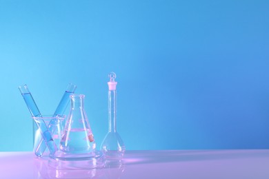 Laboratory analysis. Different glassware on table against light blue background