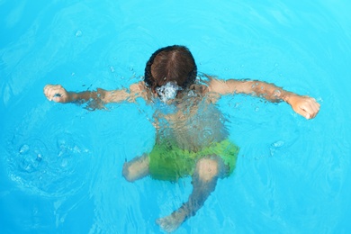 Photo of Little child in outdoor swimming pool. Dangerous situation