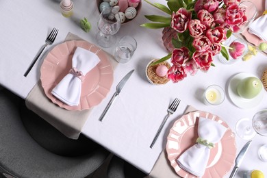 Photo of Festive table setting with beautiful flowers, top view. Easter celebration