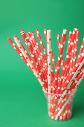Photo of Many paper drinking straws on green background
