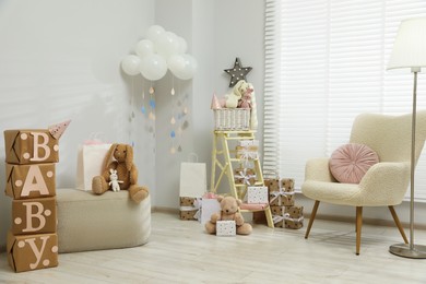 Photo of Baby shower party. Festive decor, gift boxes and toys in stylish room