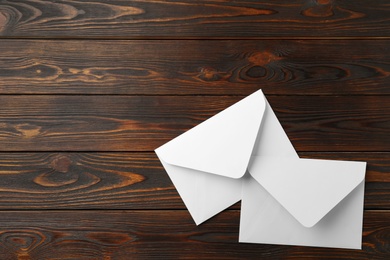 White paper envelopes on wooden background, flat lay. Space for text