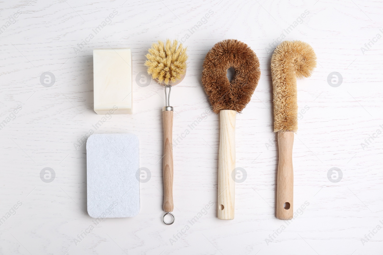 Photo of Cleaning supplies for dish washing on white wooden table, flat lay
