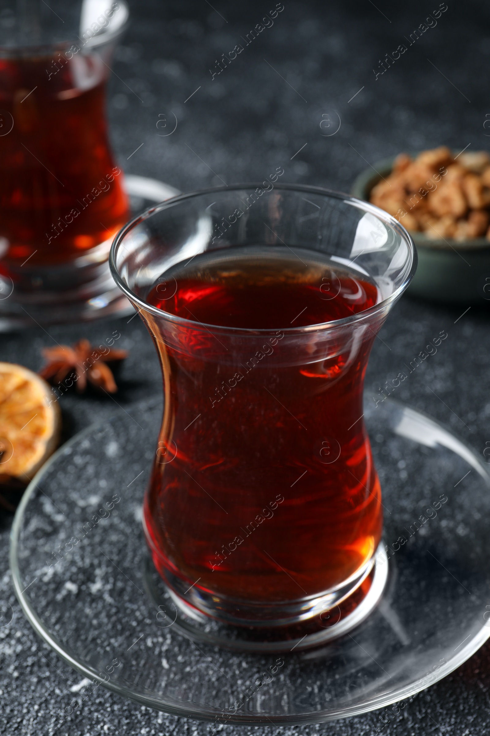 Photo of Glasses of traditional Turkish tea on grey textured table, closeup