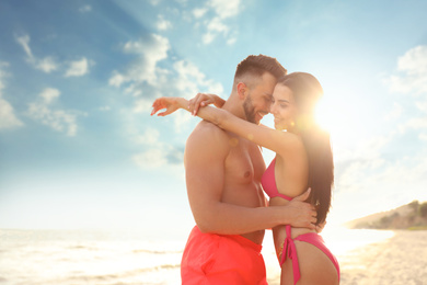Happy young couple on beach on sunny day