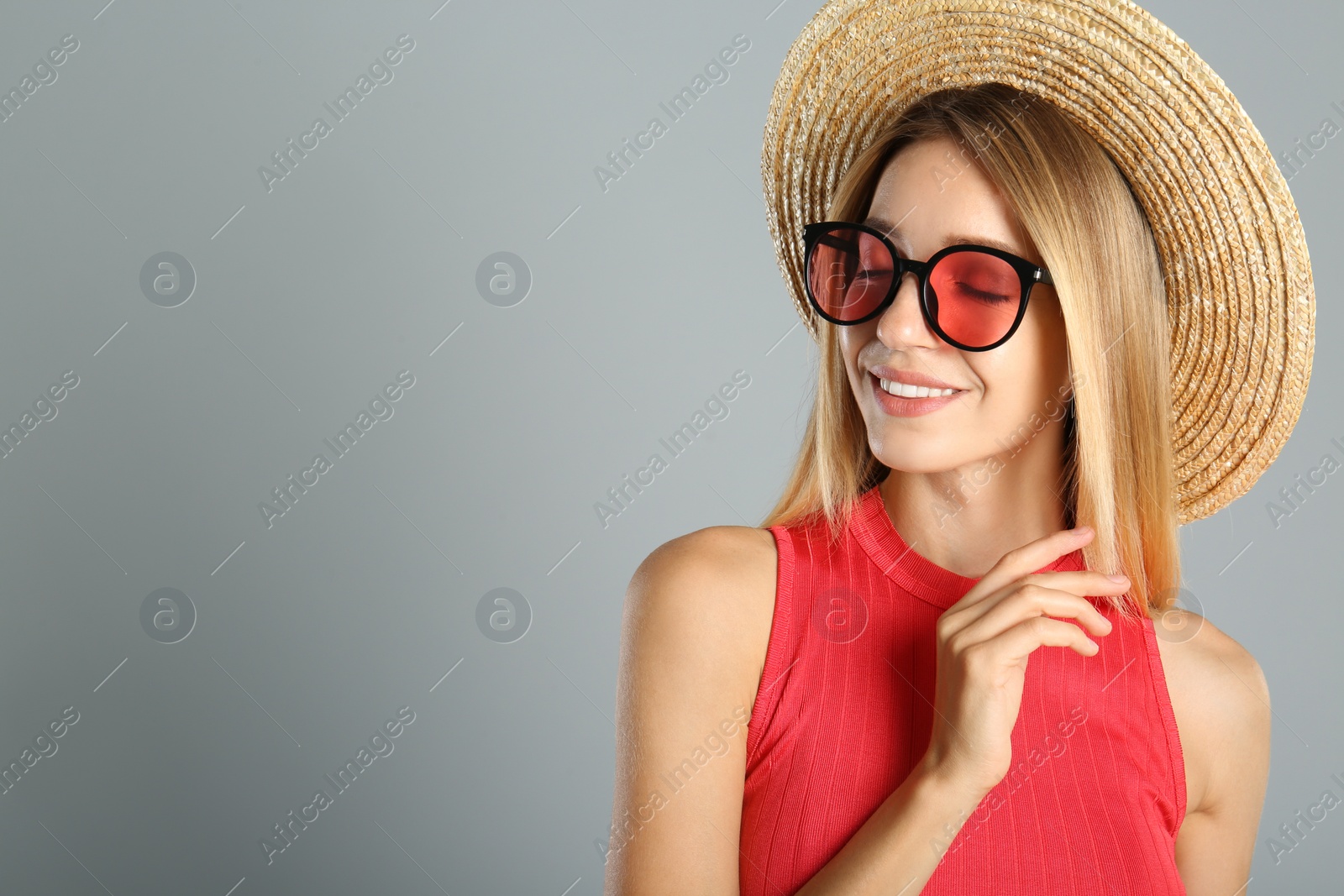 Photo of Beautiful woman in stylish sunglasses on grey background. Space for text