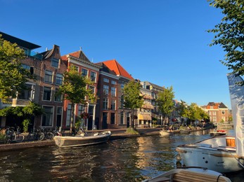 Leiden, Netherlands - August 1, 2022: Picturesque view of city canal with moored boats and beautiful buildings