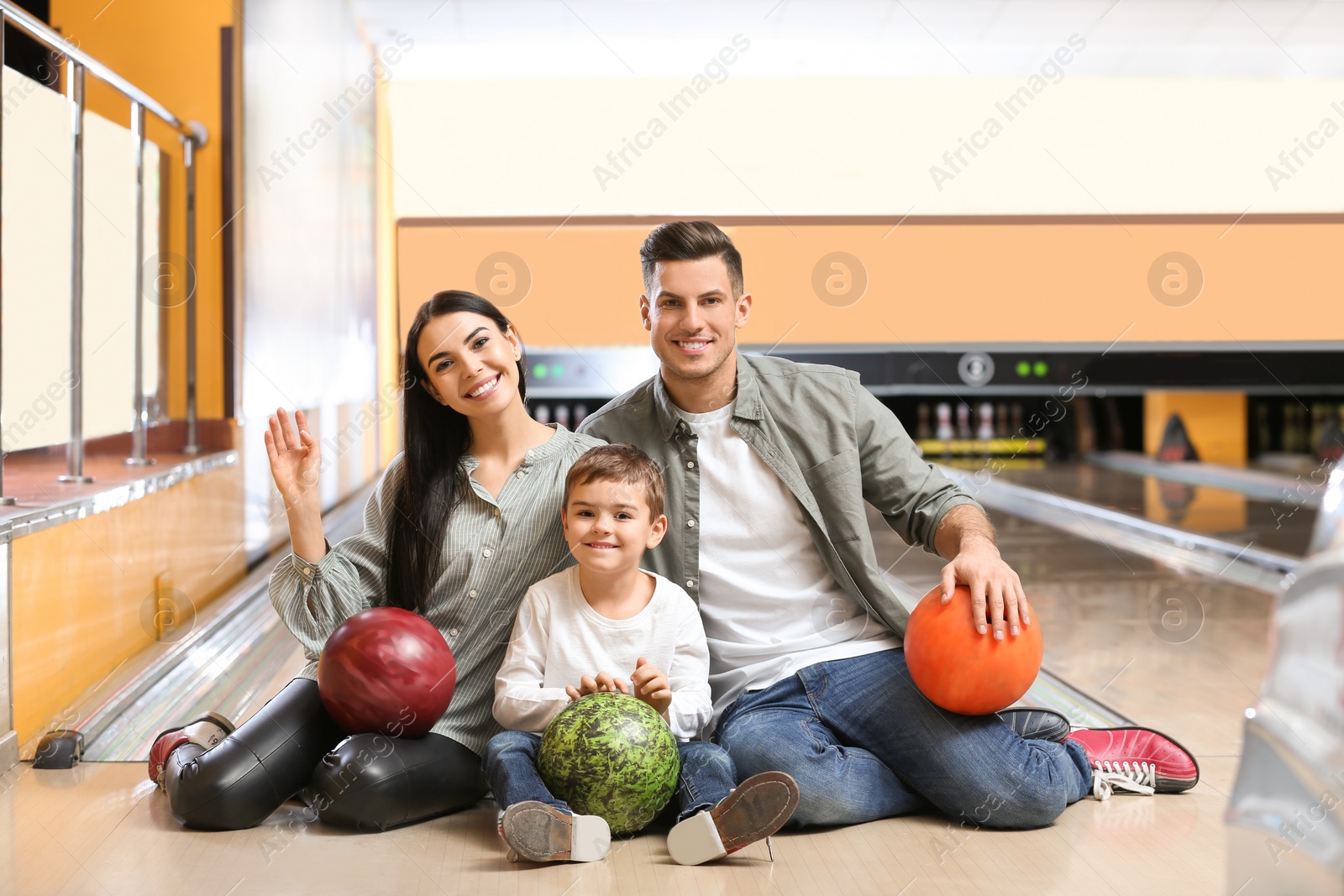 Photo of Happy family spending time together in bowling club