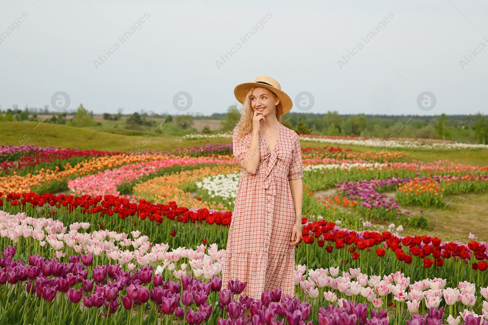 Photo of Happy woman in beautiful tulip field outdoors