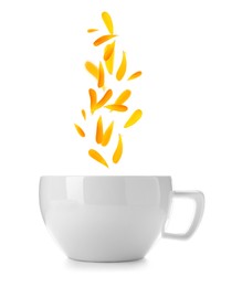 Image of Beautiful calendula petals falling into cup of freshly brewed tea on white background