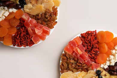 Photo of Plates with different dried fruits on white background, top view