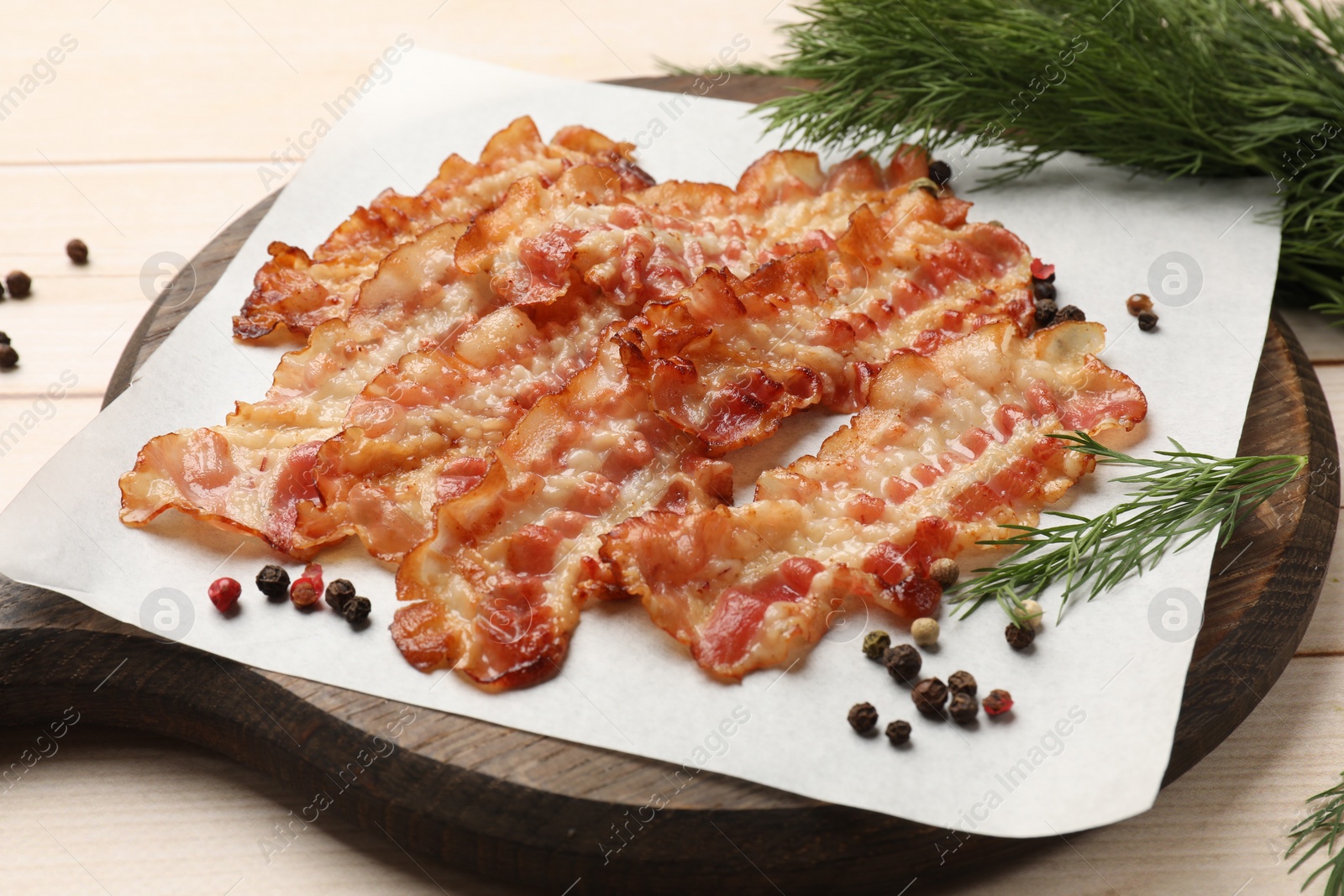 Photo of Delicious fried bacon slices on white wooden table, closeup