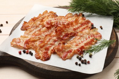 Photo of Delicious fried bacon slices on white wooden table, closeup
