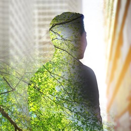 Double exposure of man and green tree in city