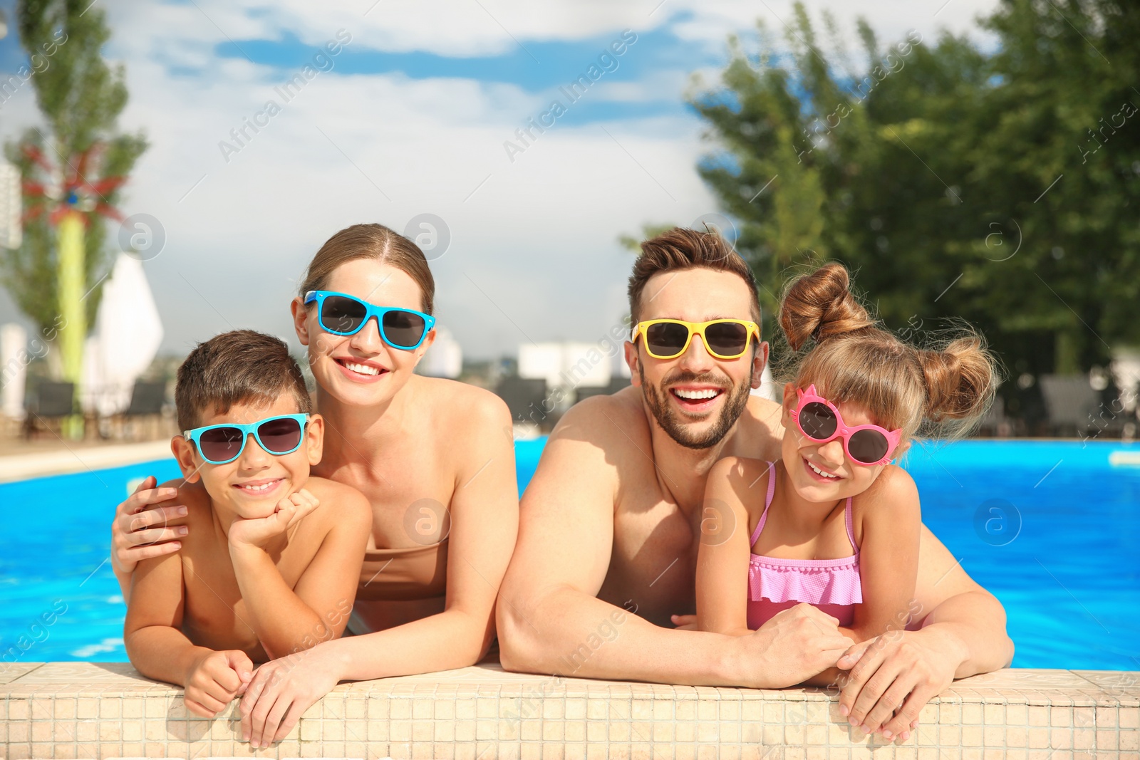 Photo of Happy family in swimming pool on sunny day