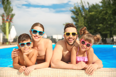 Happy family in swimming pool on sunny day