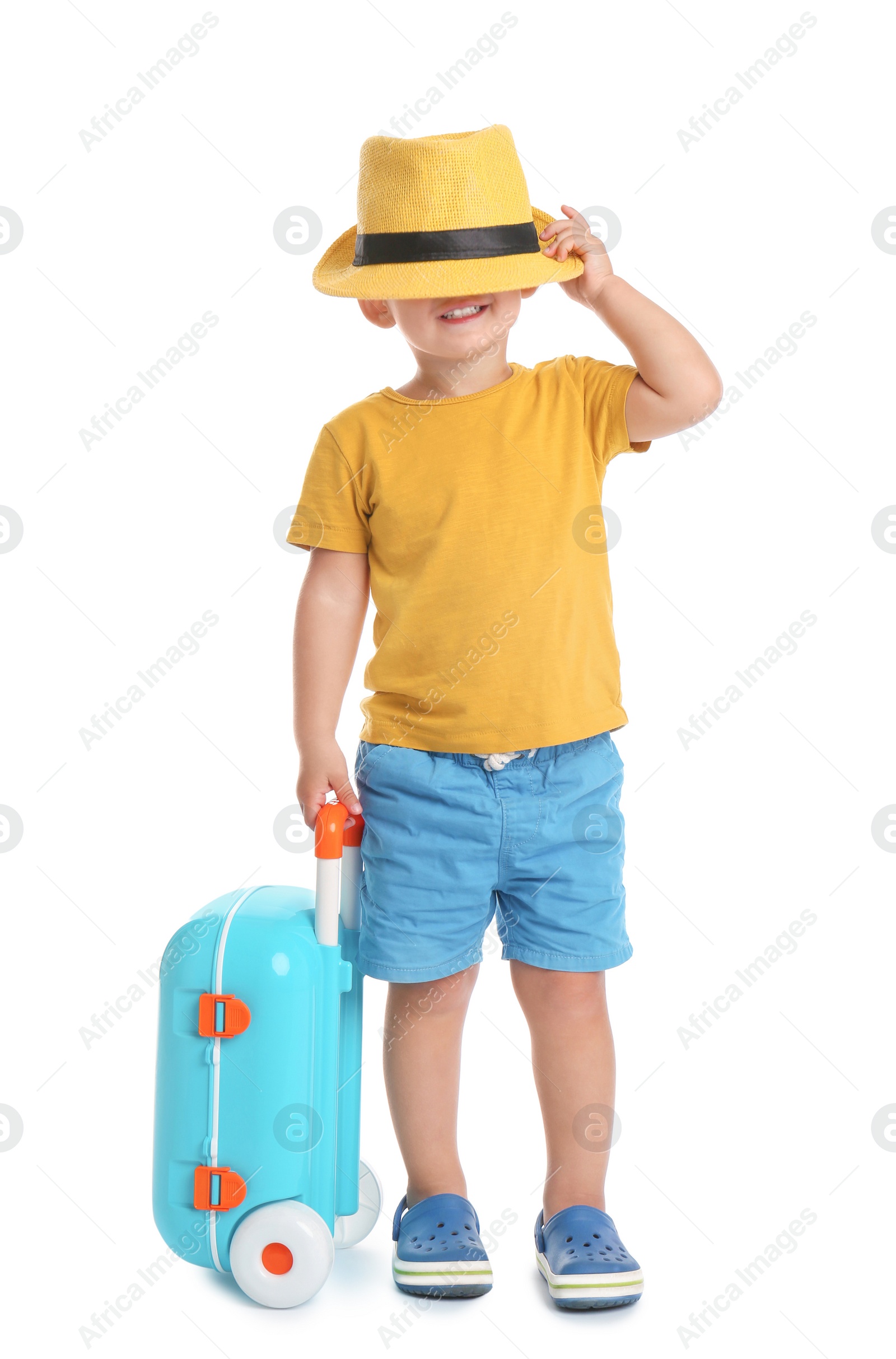 Photo of Cute little boy with hat and blue suitcase on white background