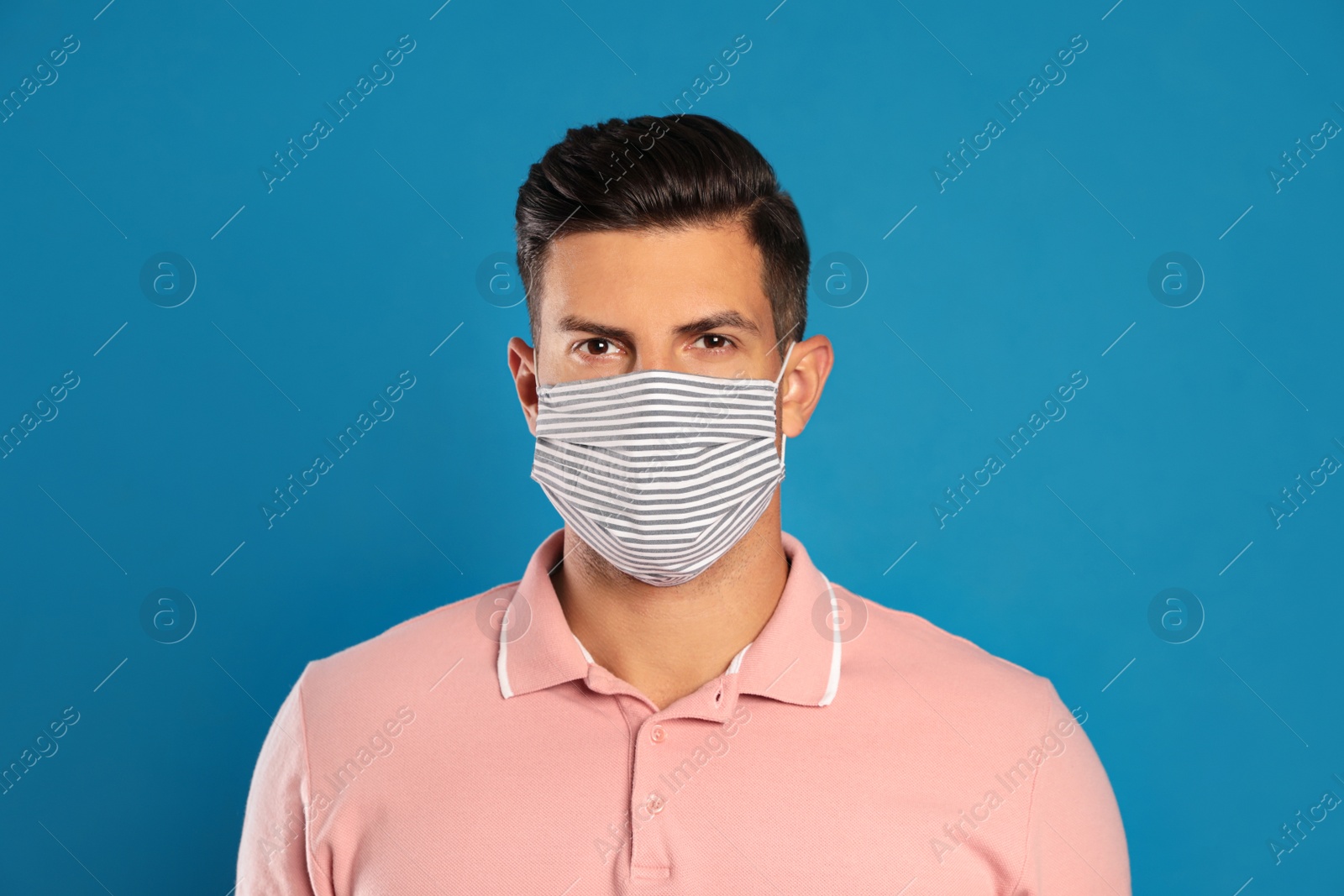 Photo of Man in protective face mask on blue background