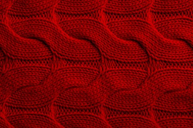 Beautiful red knitted fabric as background, top view
