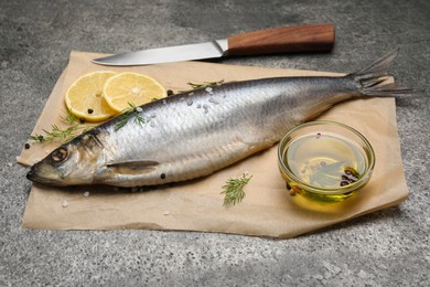 Photo of Delicious salted herring, olive oil, lemon and dill on grey table
