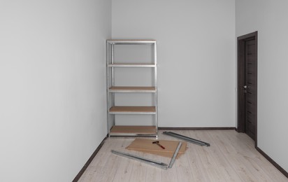 Photo of Office room with white walls and metal storage shelf