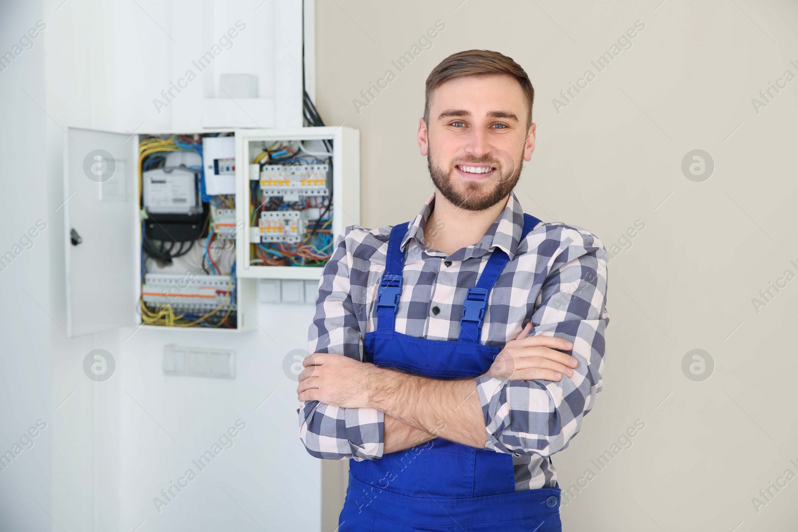 Photo of Male electrician standing near fuse board indoors