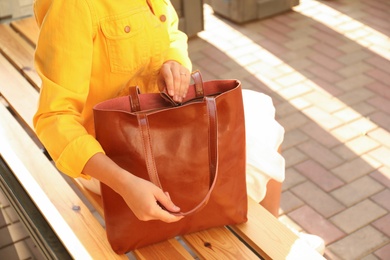 Woman with stylish shopper bag on bench outdoors, closeup