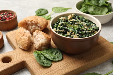 Photo of Tasty spinach dip with egg, bread and spices on grey table