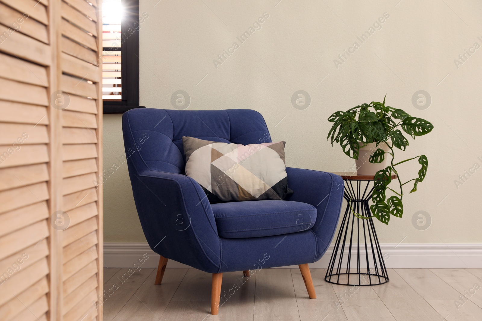 Photo of Comfortable armchair with pillow in stylish room interior
