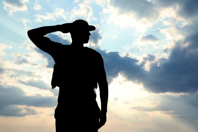 Photo of Soldier in uniform saluting outdoors. Military service