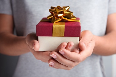 Photo of Woman holding beautiful gift box with bow, closeup