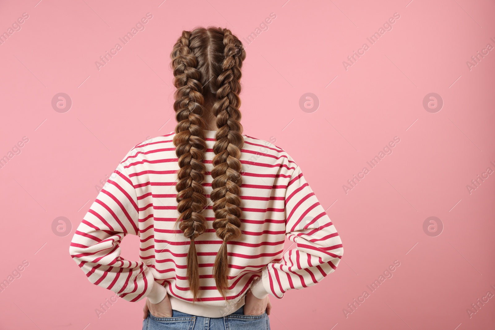 Photo of Woman with braided hair on pink background, back view. Space for text